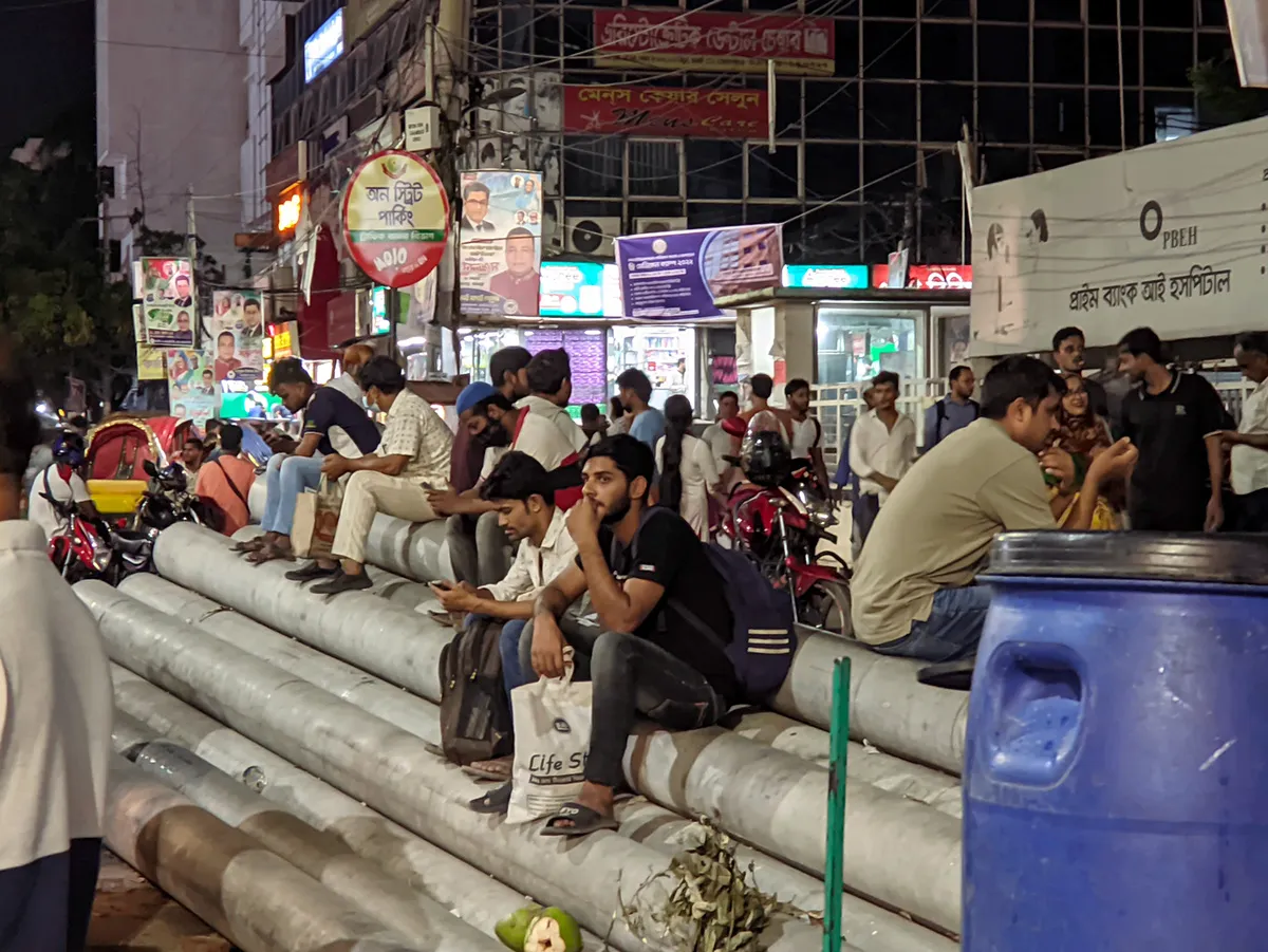 Roadside construction pillars used informally as seating.